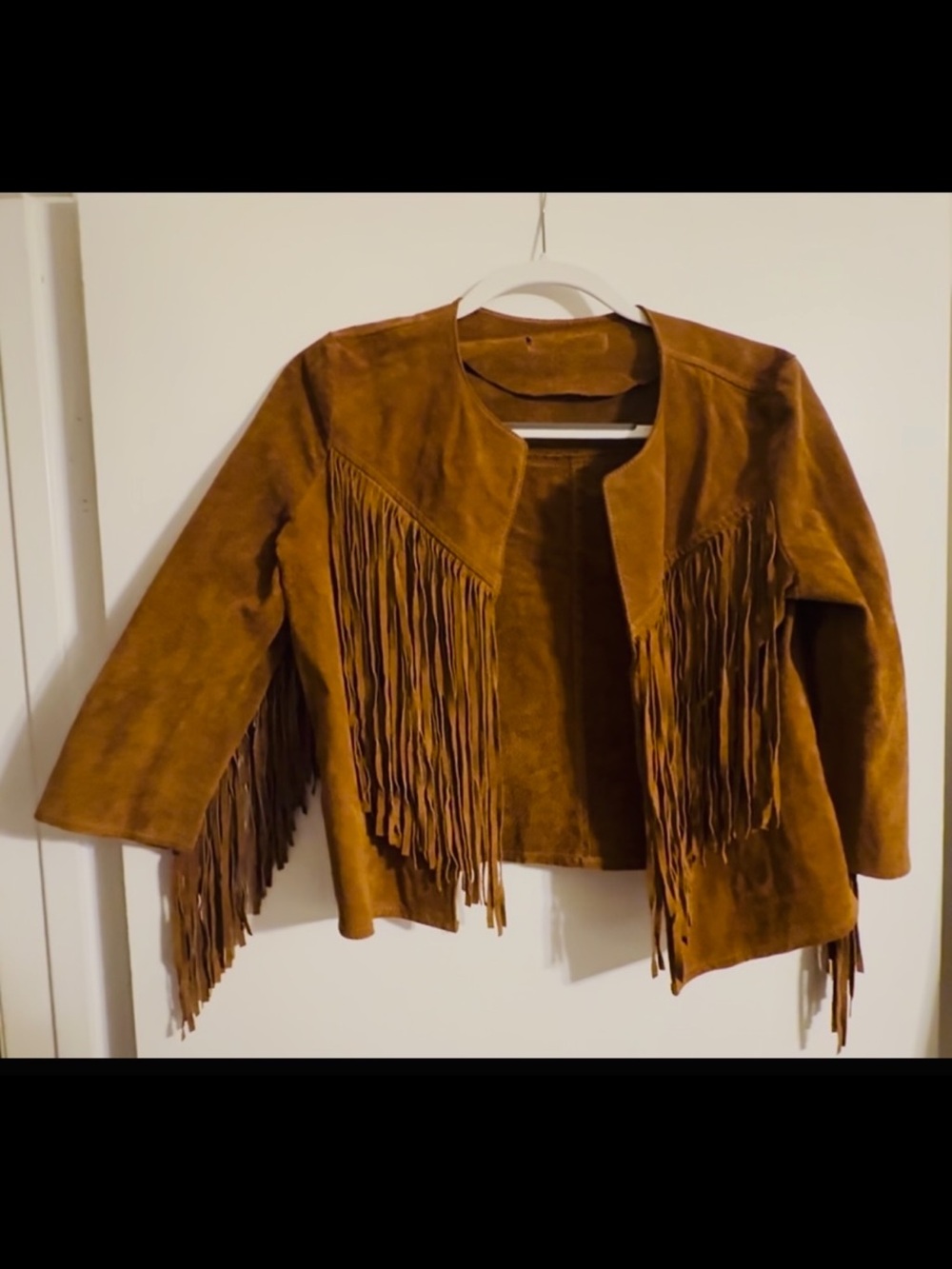 Suede tan jacket, with tassels on sleeves/back, fits sm/med, used
